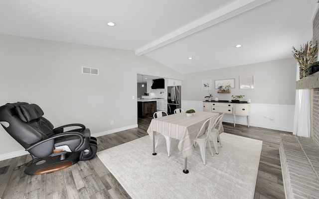 dining room featuring recessed lighting, visible vents, lofted ceiling with beams, wainscoting, and wood finished floors