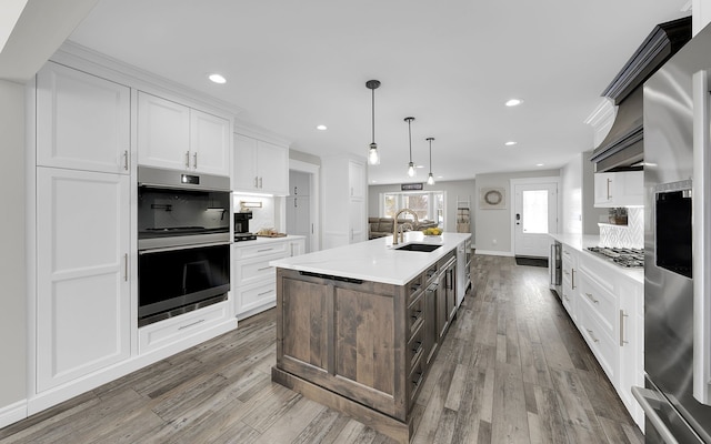 kitchen featuring light countertops, a sink, white cabinetry, and stainless steel appliances