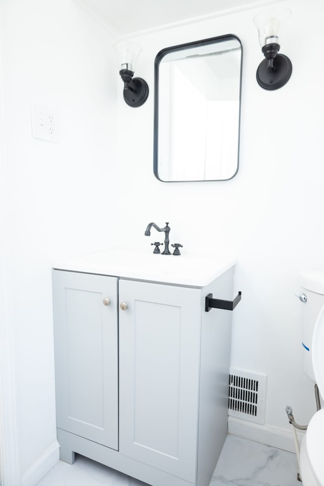 bathroom featuring visible vents, toilet, marble finish floor, and vanity