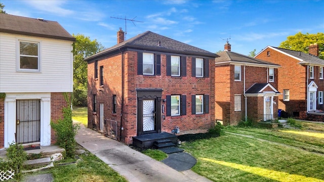 view of front facade featuring a front yard, brick siding, and a chimney