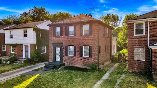 view of front of property with a front lawn and brick siding