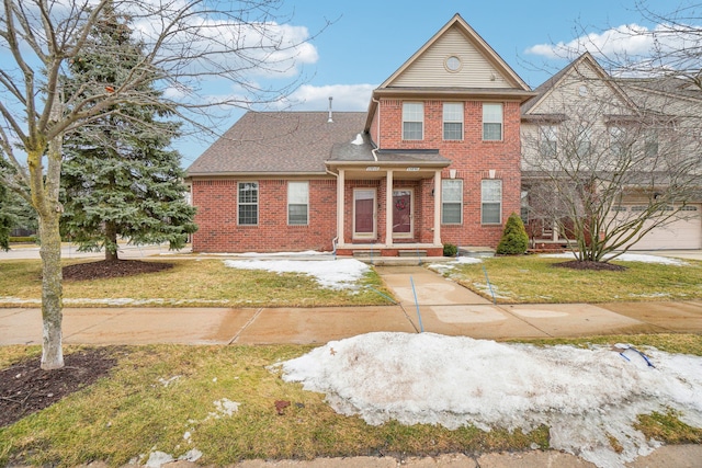 traditional home featuring brick siding, roof with shingles, and a front lawn