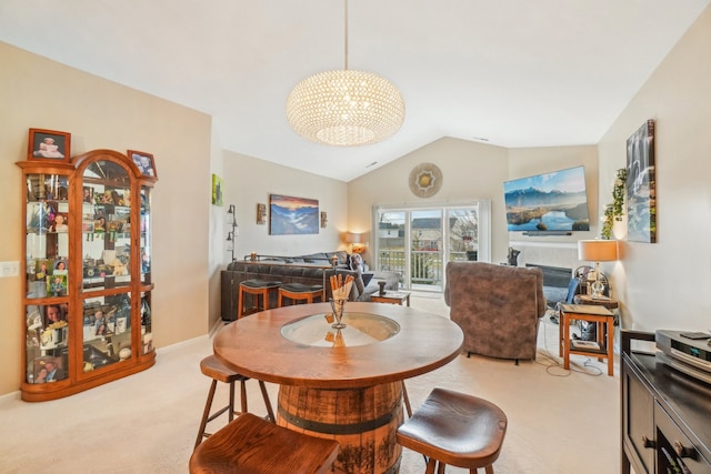 dining room with light carpet, a notable chandelier, baseboards, and lofted ceiling