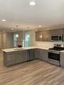 kitchen with kitchen peninsula, appliances with stainless steel finishes, light hardwood / wood-style flooring, and decorative light fixtures