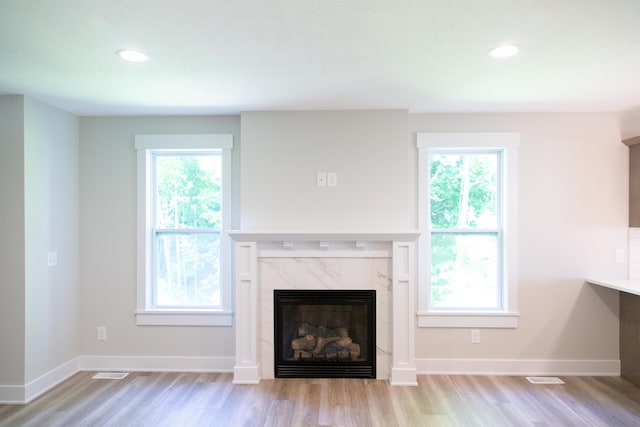 unfurnished living room with light hardwood / wood-style flooring and a high end fireplace