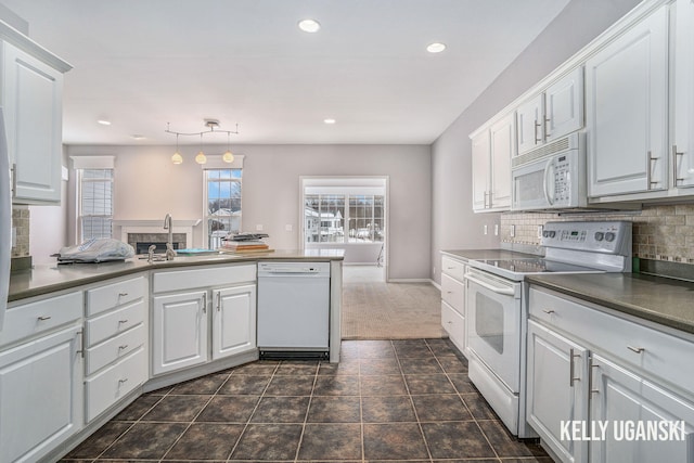 kitchen featuring white appliances, sink, pendant lighting, white cabinets, and decorative backsplash