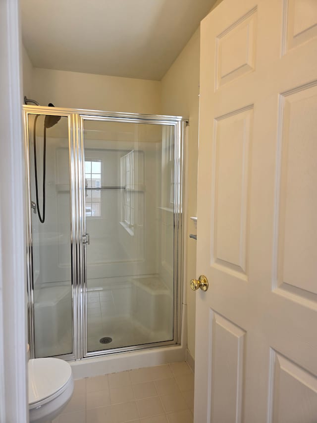 bathroom featuring toilet and an enclosed shower