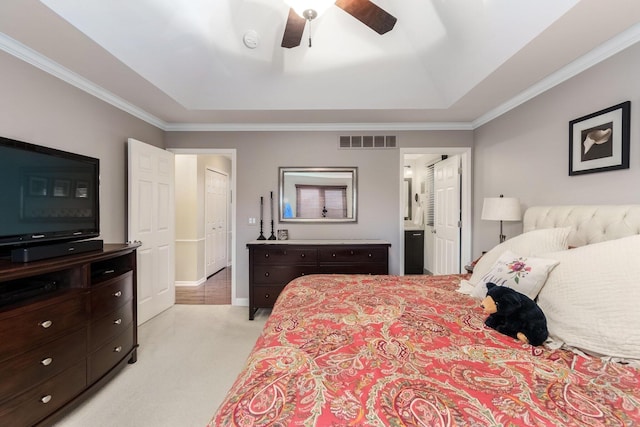 bedroom featuring a raised ceiling, visible vents, ornamental molding, light carpet, and baseboards