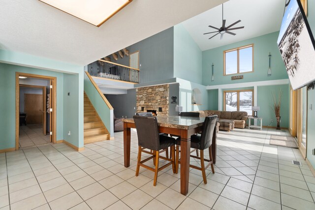 14113 Grandview Dr, Cement City, MI 49233 - dining space with stairway, a high ceiling, visible vents, a ceiling fan, and light tile patterned flooring