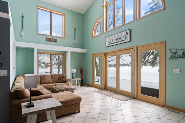 14113 Grandview Dr, Cement City, MI 49233 - living room featuring visible vents, baseboards, a high ceiling, and light tile patterned floors