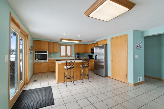 14113 Grandview Dr, Cement City, MI 49233 - kitchen with plenty of natural light, visible vents, appliances with stainless steel finishes, and a breakfast bar area