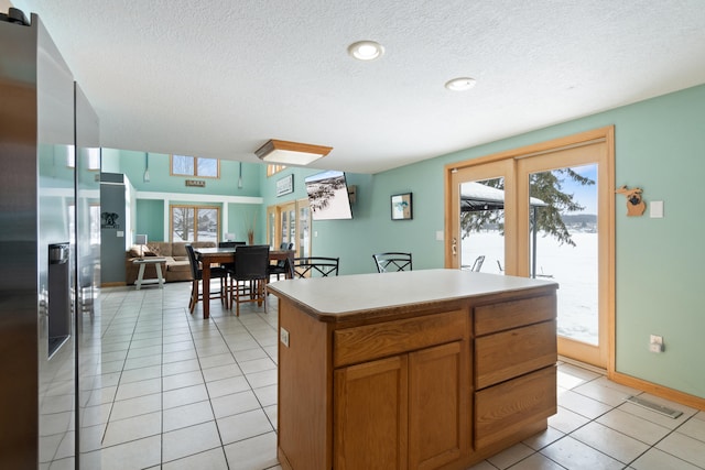 14113 Grandview Dr, Cement City, MI 49233 - kitchen with plenty of natural light, stainless steel refrigerator with ice dispenser, a textured ceiling, and light tile patterned floors