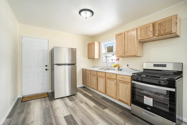 kitchen featuring stainless steel appliances, light hardwood / wood-style floors, light brown cabinets, ornamental molding, and sink