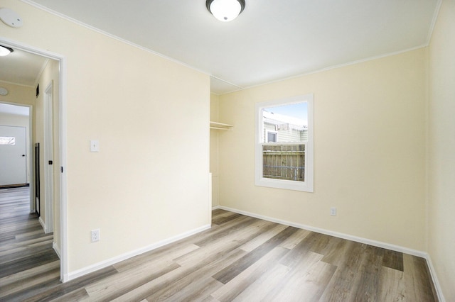 spare room with light hardwood / wood-style floors and crown molding