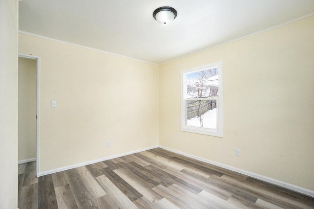 unfurnished room with hardwood / wood-style flooring and crown molding