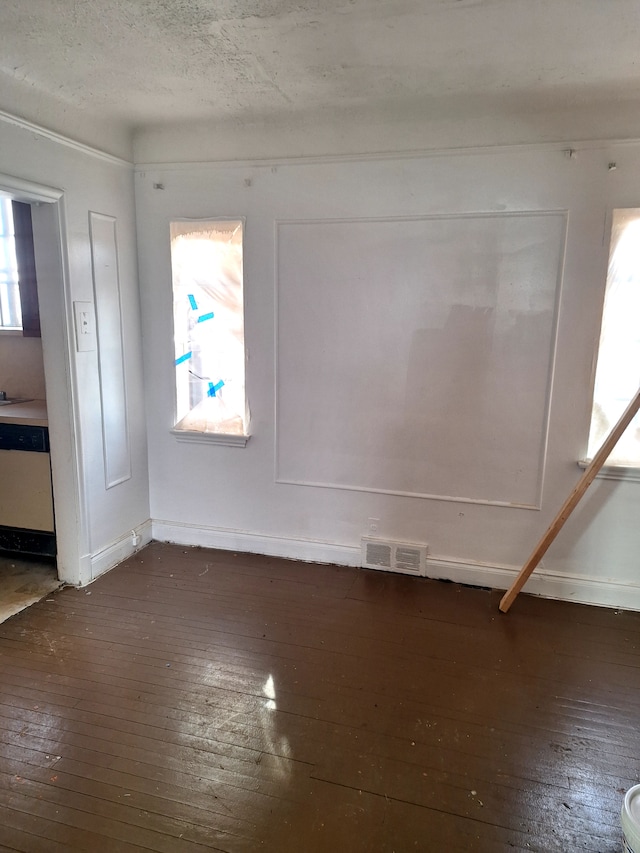 empty room with dark hardwood / wood-style flooring and a textured ceiling