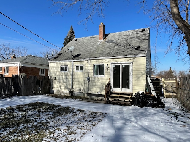 view of snow covered back of property