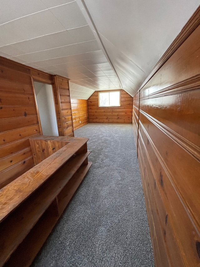 bonus room with vaulted ceiling, carpet floors, and wooden walls