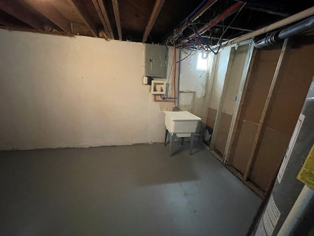 basement featuring electric panel and sink