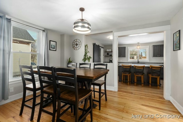 dining area featuring light hardwood / wood-style flooring, sink, and a healthy amount of sunlight