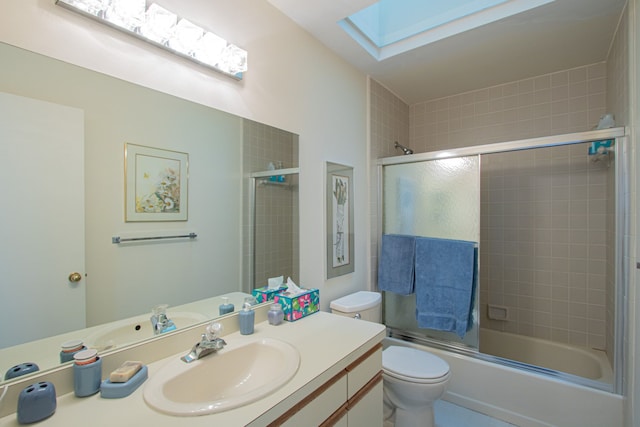 full bathroom with combined bath / shower with glass door, vanity, toilet, and a skylight