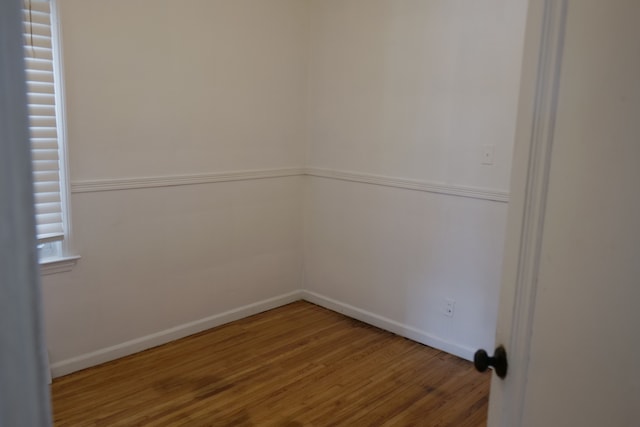 empty room with baseboards and wood finished floors