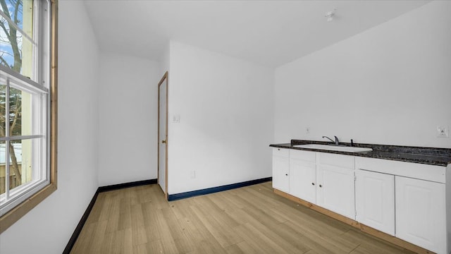 kitchen featuring white cabinets, light hardwood / wood-style flooring, and sink