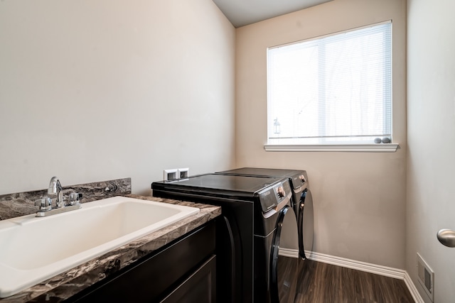 clothes washing area featuring baseboards, dark wood finished floors, visible vents, separate washer and dryer, and a sink