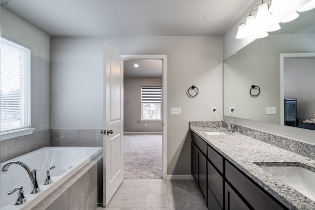 full bathroom featuring double vanity, a garden tub, tile patterned flooring, and a sink