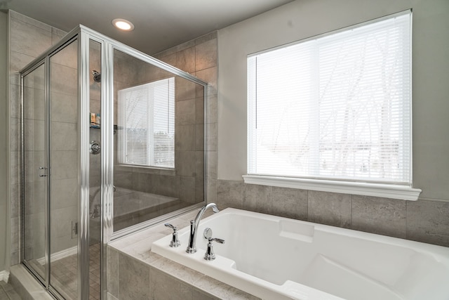 full bathroom featuring a shower stall and a bath