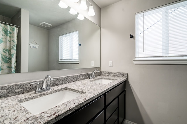 bathroom featuring double vanity, a sink, and visible vents