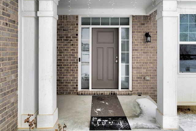 doorway to property featuring brick siding