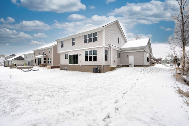 snow covered rear of property featuring entry steps