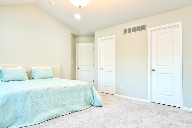 carpeted bedroom featuring visible vents, vaulted ceiling, and baseboards