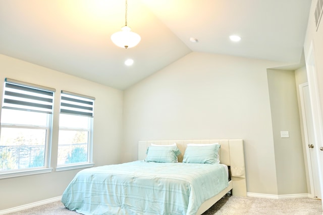 bedroom with lofted ceiling, baseboards, and light colored carpet