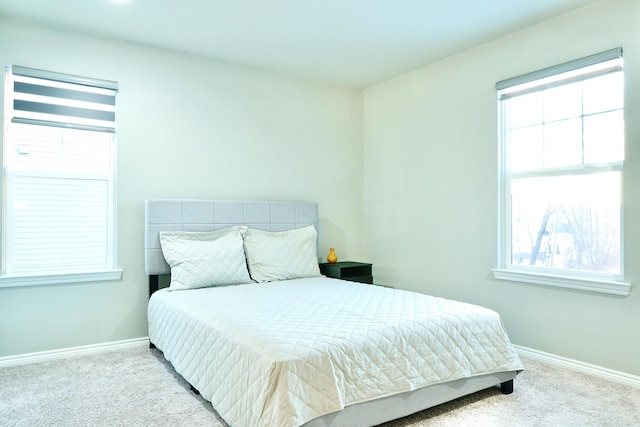 bedroom featuring light carpet and baseboards