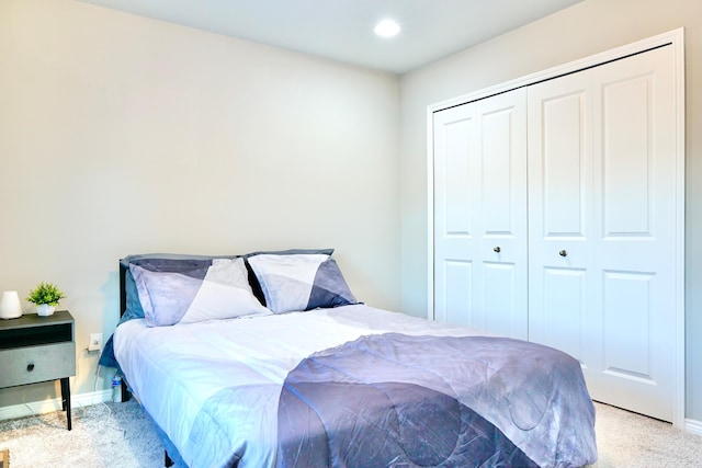 bedroom featuring baseboards, a closet, recessed lighting, and light colored carpet