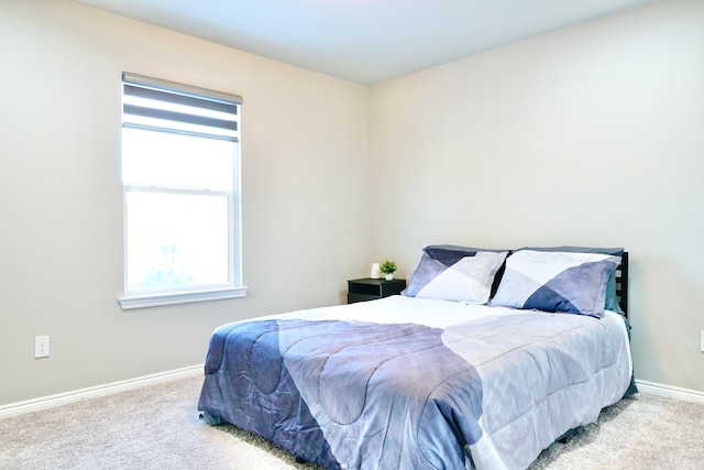 bedroom featuring light carpet and baseboards