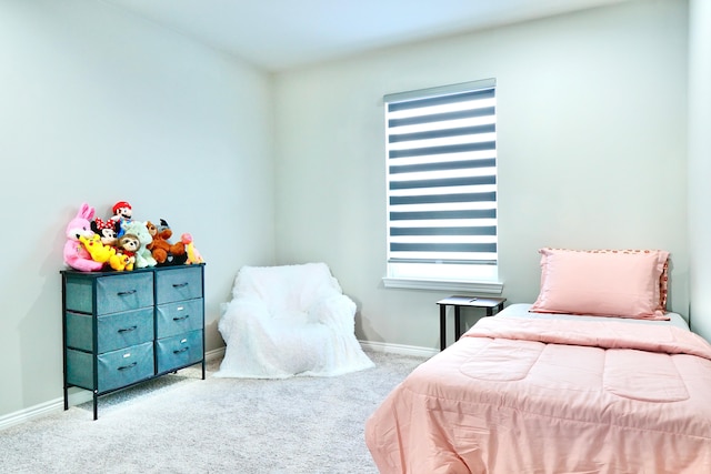 bedroom with baseboards, multiple windows, and light colored carpet