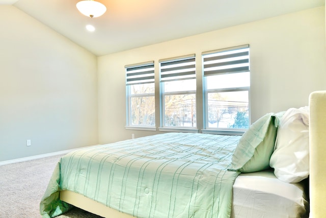 carpeted bedroom featuring lofted ceiling and baseboards