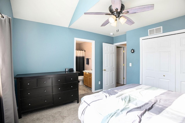 bedroom featuring ceiling fan, a closet, ensuite bath, and light colored carpet