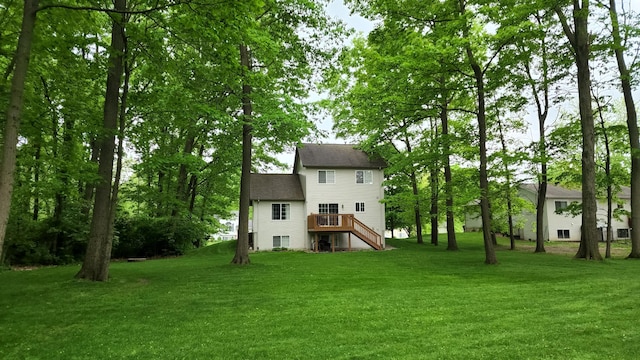 rear view of property with a deck and a lawn