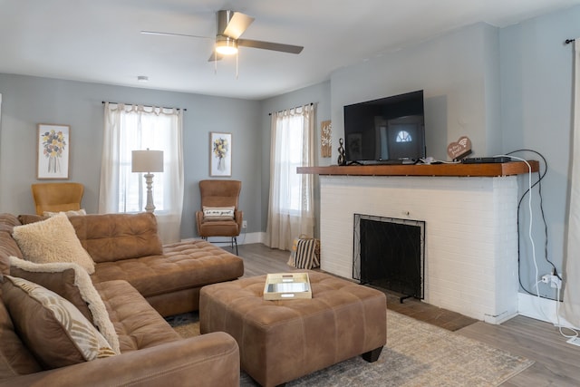 living area featuring baseboards, a healthy amount of sunlight, and wood finished floors