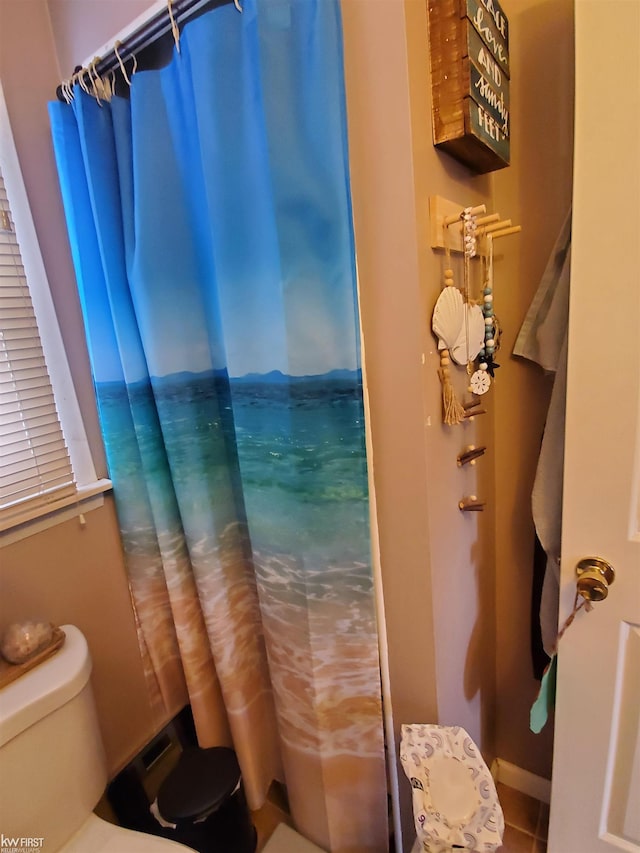 bathroom with tile patterned flooring, curtained shower, and toilet