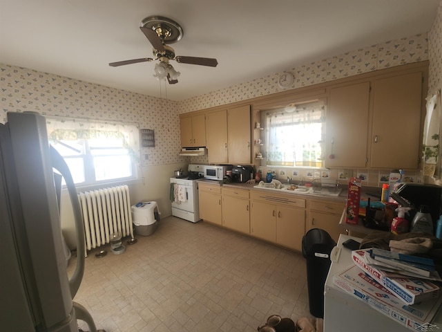 kitchen featuring wallpapered walls, white appliances, radiator, light countertops, and a healthy amount of sunlight