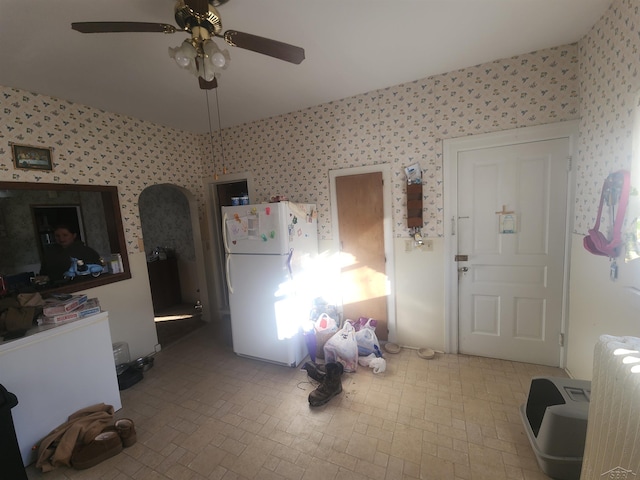 interior space featuring ceiling fan and wallpapered walls