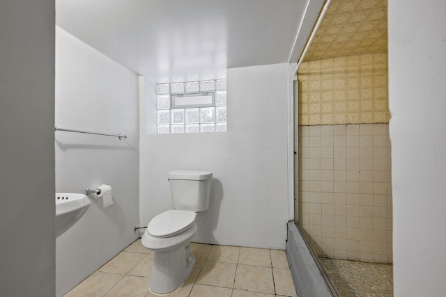 bathroom with wallpapered walls, a tile shower, toilet, and tile patterned floors