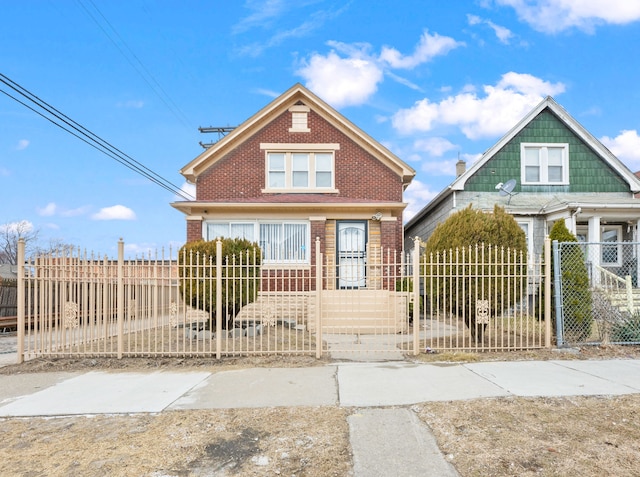 view of front of house featuring brick siding, a fenced front yard, and a gate