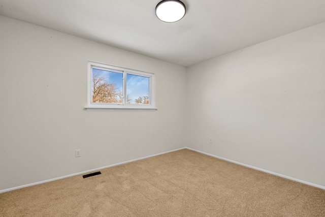 empty room with light carpet, visible vents, and baseboards