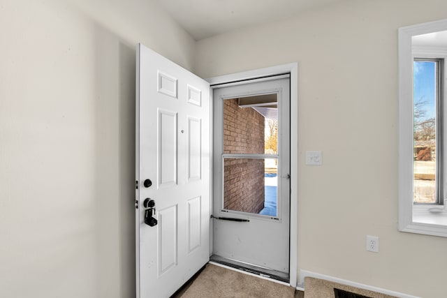 doorway with carpet and a healthy amount of sunlight